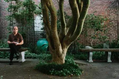 丹尼斯·麦克纳利坐在一棵树旁